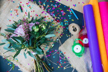 Obraz premium master florist prepares top-level content for the event using flowers and craft packaging in different colors, top view of layout on the table, top level event