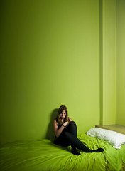 Young woman alone on a green high ceiling room