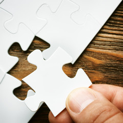Hand with missing jigsaw puzzle piece. Business concept image for completing the final puzzle piece