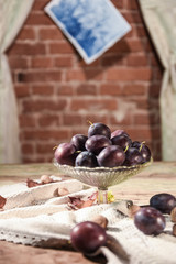 plums in a bowl on wooden background