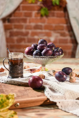 Plums and black tea on the table