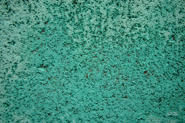 Fototapeta na wymiar 薄緑色に塗られたコンクリートブロックの側面のクローズアップ