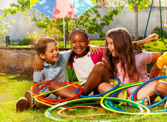 Kids portrait with hula hoops together on grass