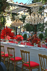 Autumn harvest decorated table in red color. Decoration with red apples and pomegranate. Stylish interior design.