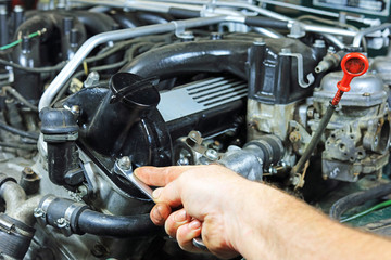 mechanics Hand Using A Spanner To Tighten A Nut On A Old Classic Car