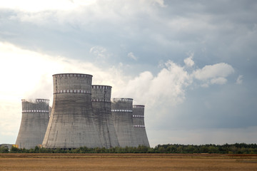 Cooling towers of the nuclear power plant against the cloudy sky. Ecology and air pollution concept.