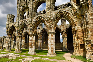 Fototapeta na wymiar Eroded stone arches and pillars of the Gothic ruins of Whitby Abbey church chancel North York Moors National Park England