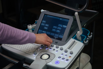 Doctor adjusts ultrasound scan equipment for sonography diagnostics