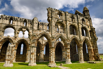 Stone arches and pillars of the 13th century Gothic ruins of Whitby Abbey church chancel North York Moors National Park England