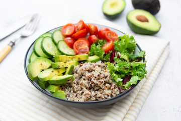 Healthy food. budha bowl with quinoa, avocado, cucumber, salad, tomatoe, olive oil. Clean eating, diet food. Bright background.