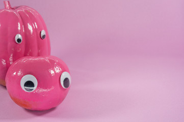 company of two fun pumpkins on pastel pink background with copyspace. Halloween concept
