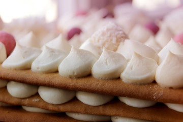 Fototapeta na wymiar white air whipped cream on a puff cake of thick honey cakes, homemade dessert concept, close-up