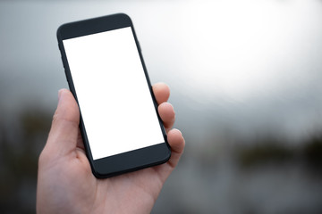 Close-up of smartphone with mockup in man hand.