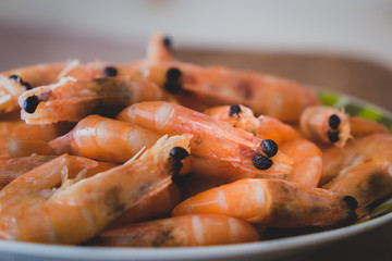 boiled shrimp lie on a plate. these shrimp are unpeeled. Shrimp close up