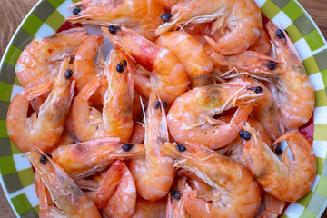 boiled shrimp lie on a plate. these shrimp are unpeeled