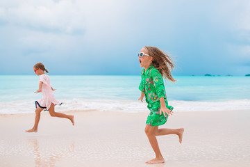 Fototapeta premium Little girls having fun enjoying vacation on tropical beach