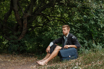 Businessman sitting on the ground on desert island