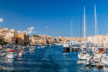 Fototapeta na wymiar Boats between Senglea and Birgu towns, Valletta in the background.