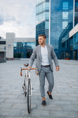 Businessman with briefcase and bicycle in downtown