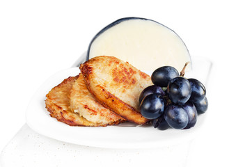 Roast pork with grapes and a piece of cheese in the background. Selective focus