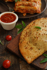 Calzone - Italian folded CheesePizza on rustic wooden background