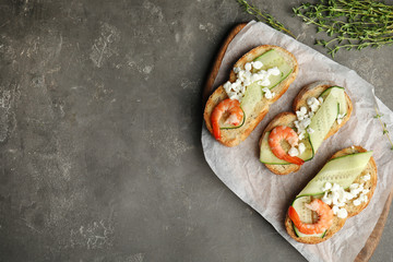 Delicious bruschettas with shrimps on grey table, flat lay. Space for text