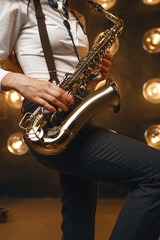 Obraz premium Female saxophonist plays the saxophone on stage