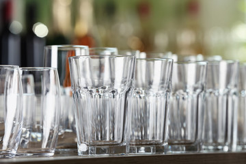 Empty glasses on wooden table against blurred background