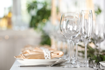 Table setting with empty glasses, plates and cutlery indoors