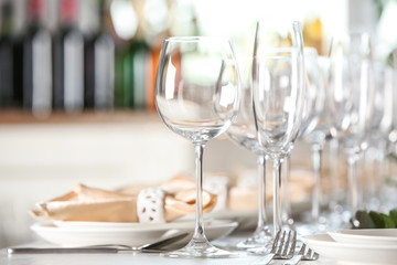 Table setting with empty glasses, plates and cutlery indoors