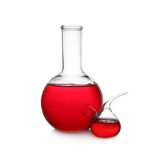 Laboratory glassware with red liquid on white background