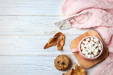 Flat lay composition with cup of hot drink on white wooden table, space for text. Cozy autumn atmosphere