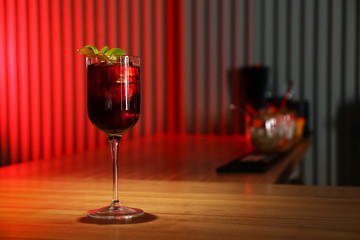 Glass of delicious cocktail with vodka on wooden counter in bar. Space for text