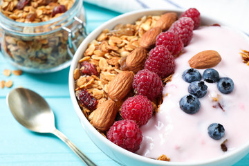 Tasty homemade granola served on blue wooden table, closeup. Healthy breakfast