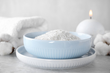 Fototapeta na wymiar White sea salt for spa scrubbing procedure on grey marble table
