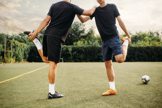 Two soccer players doing stretching exercise