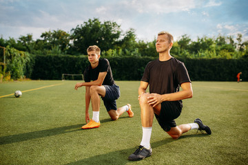Obraz premium Male soccer players doing stretching exercise