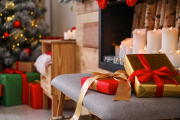 Christmas gifts on chair in stylish room interior