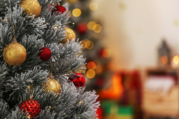 Beautiful Christmas tree decorated with balls against blurred festive lights, closeup. Space for text