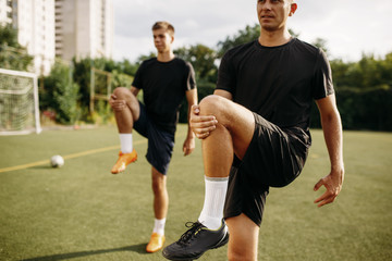 Male soccer players doing stretching exercise