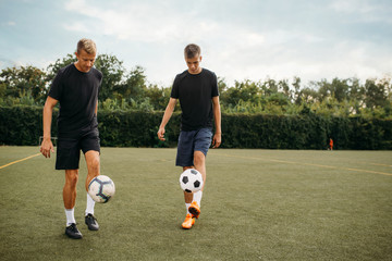 Soccer players training with balls on the field