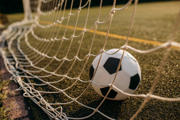 Naklejka premium Soccer ball in the gate net, nobody