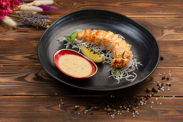 salmon slices baked in breadcrumbs on black round plate
