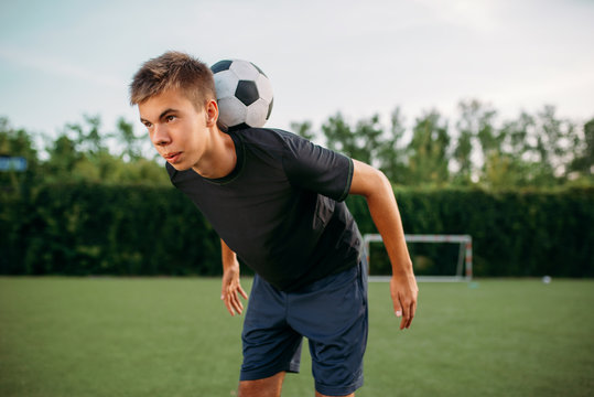 Soccer player keeps balance with ball on his neck
