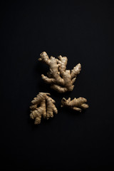 three clusters of ginger root on dark chalkboard background, fresh ginger with copyspace, copy space