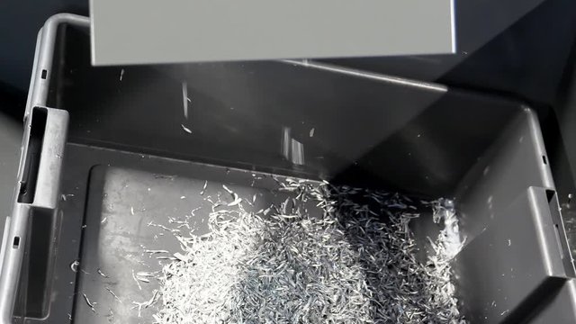 Waste metal chips, shavings or swarf being extruded out of the CNC machine into the box.