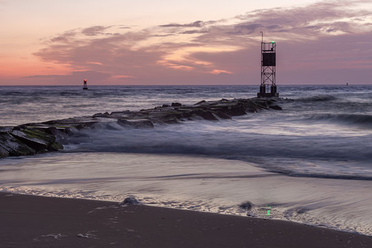 Ocean Beach Breakwater with Sunrise and Waves with Colorful Sky