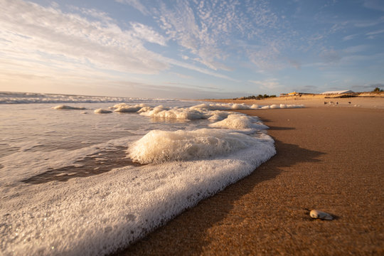 Seafoam Waves on the Beach with Blue Sky and Whispy Clouds on a Summer Morning