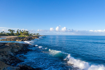 Fototapeta na wymiar Waves crash against the shore off of Oahu, Hawaii.