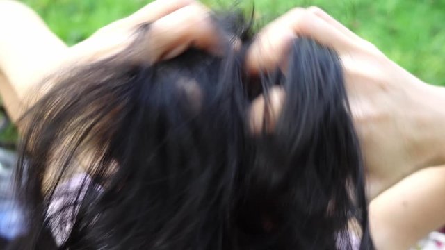 Woman scratching her head and her has Dandruff on the scalp.
